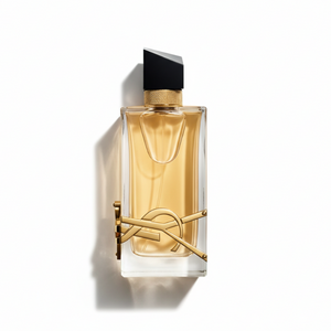 YSL Libre Eau de Parfum held by elegant woman's hand with manicured nails and gold rings on white background
